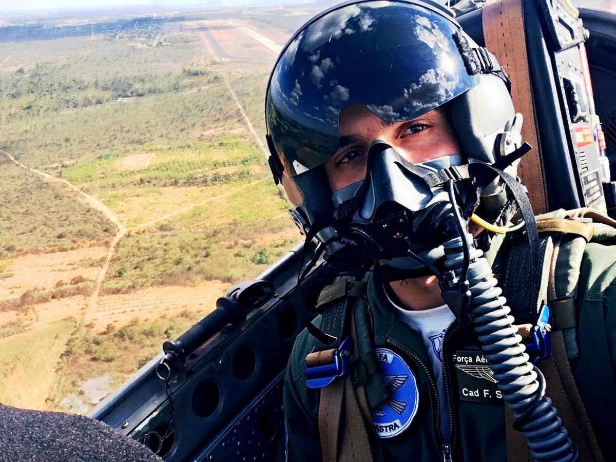 Rafael Francisco no cockpit, de capacete e máscara, com a pista ao fundo